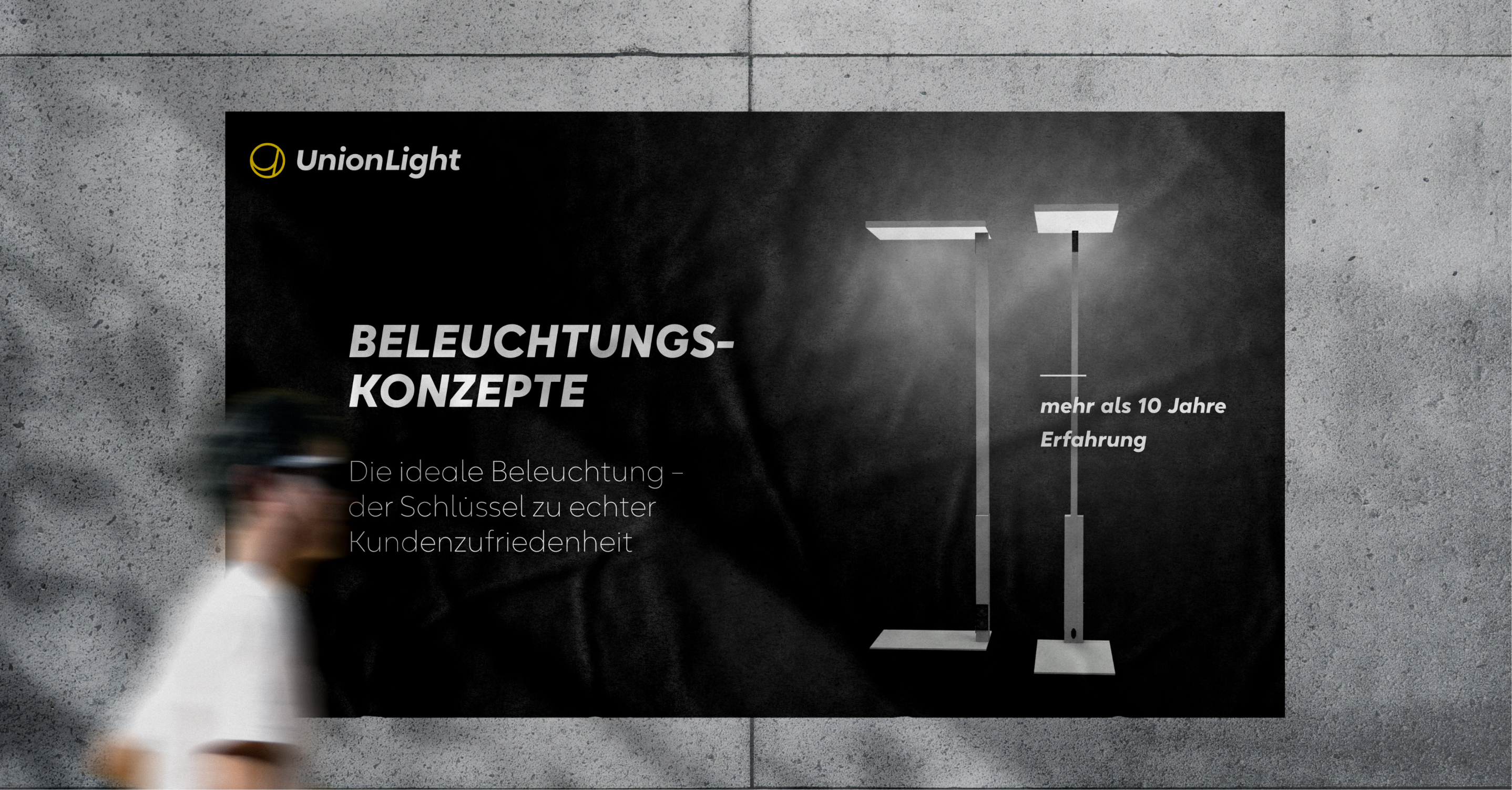 Person läuft an Unionlight Plakat vorbei. Plakat zeigt 2 Lampen. Es geht um Beleuchtungskonzepte